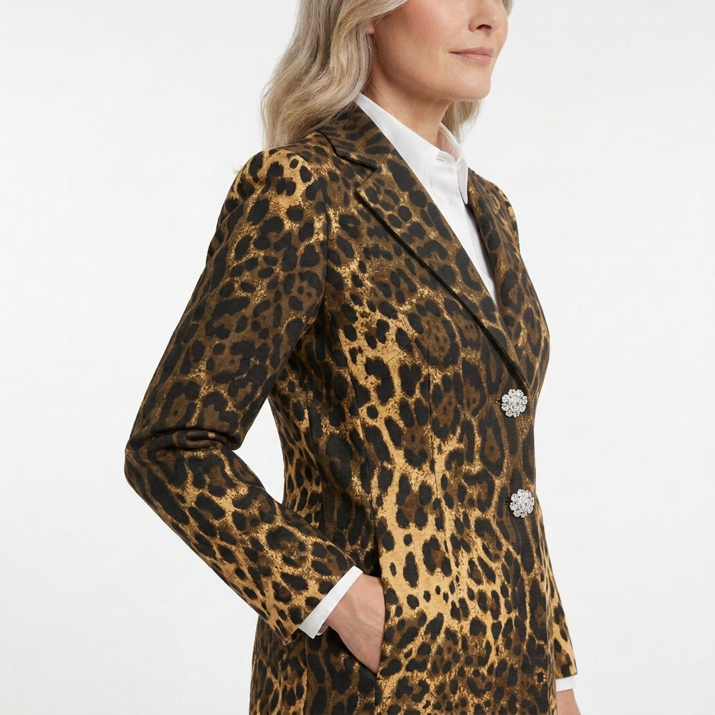 A woman wearing a leopard-print blazer over a white collared shirt, shown from the side against a plain white studio background.