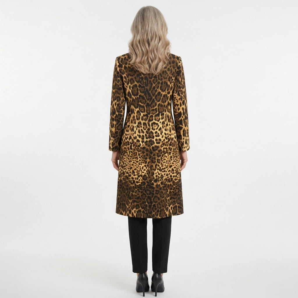 A woman viewed from behind wearing a leopard-print coat over black pants and black heels, standing against a plain light gray studio background.